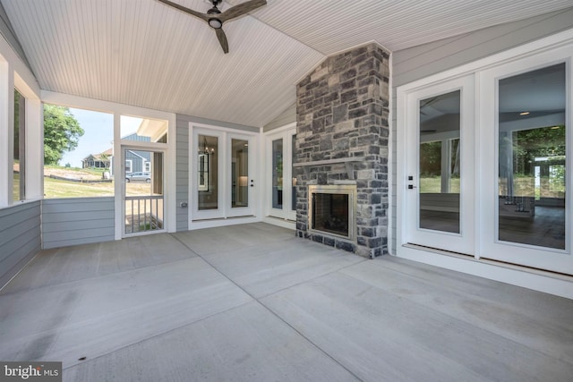 view of patio / terrace featuring ceiling fan and an outdoor stone fireplace