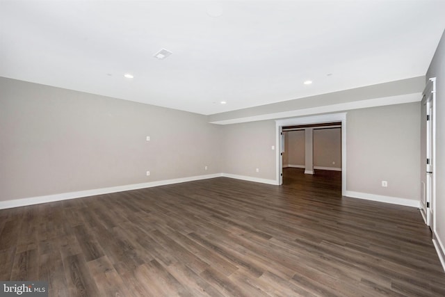 unfurnished bedroom featuring dark wood-type flooring and a walk in closet