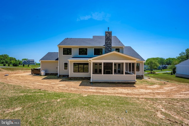 back of property with a sunroom and a lawn