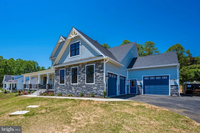 craftsman house with a porch, a garage, and a front yard