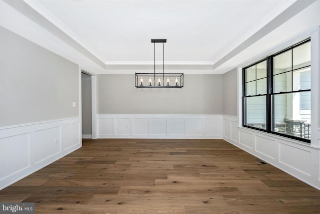 unfurnished dining area with dark wood-type flooring, crown molding, and a chandelier