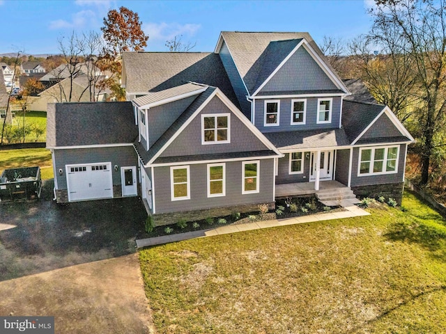 craftsman-style home with a garage, covered porch, and a front yard