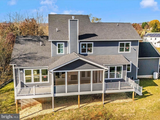 back of house with a sunroom, central AC unit, and a lawn