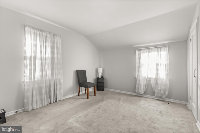 living area featuring lofted ceiling and light carpet