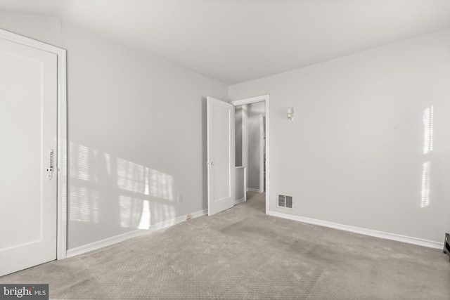 unfurnished room with vaulted ceiling and light carpet