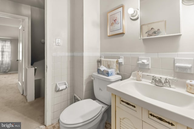 bathroom with vanity, tile walls, and toilet