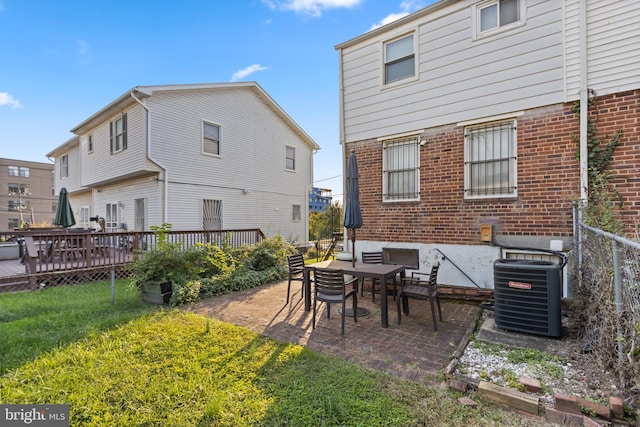 back of house with central air condition unit, a patio, and a lawn