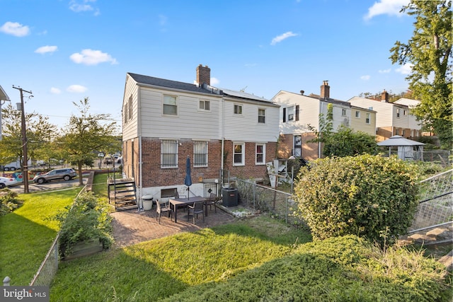 back of house with a yard, a patio area, and central air condition unit