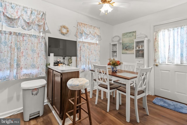 dining space with dark wood-type flooring and ceiling fan