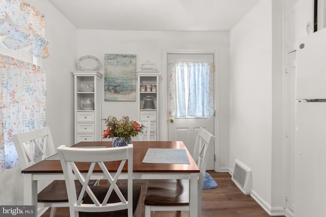 dining space with dark hardwood / wood-style flooring