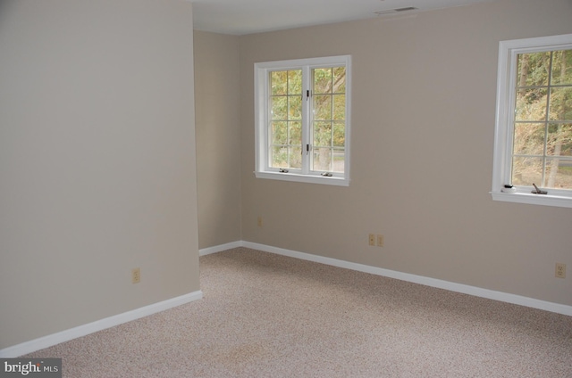 unfurnished room featuring light carpet