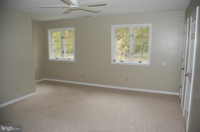 carpeted spare room featuring ceiling fan