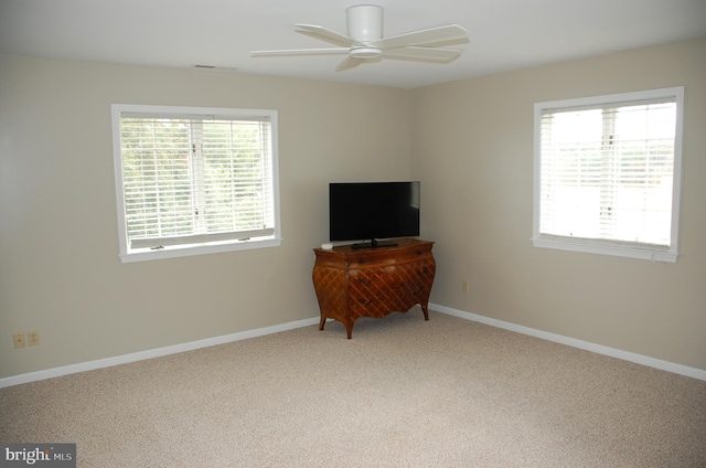 living area with light carpet, a healthy amount of sunlight, and ceiling fan