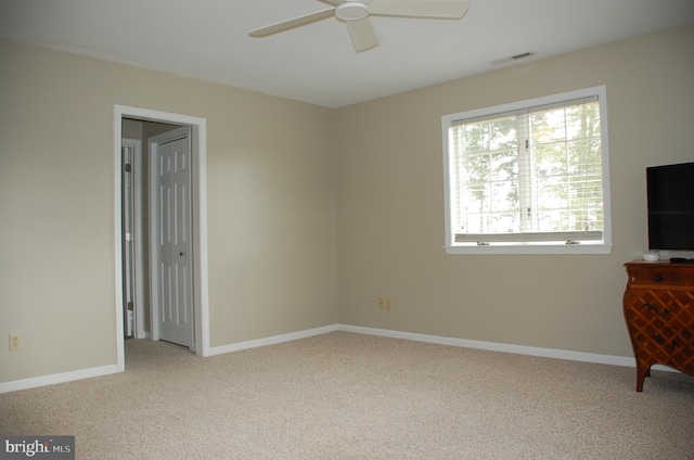 interior space featuring light colored carpet and ceiling fan