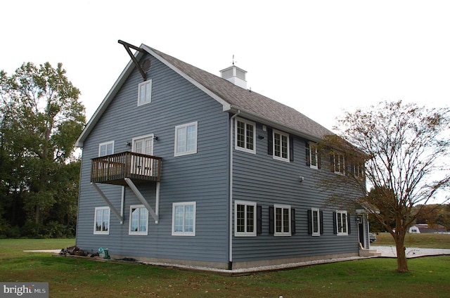 exterior space featuring a balcony and a yard