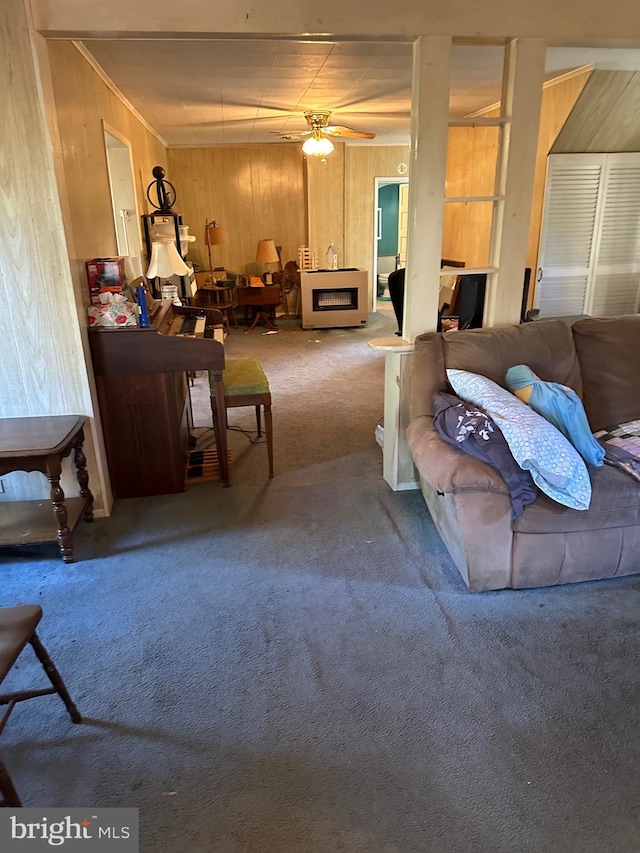 carpeted living room with ceiling fan and wood walls