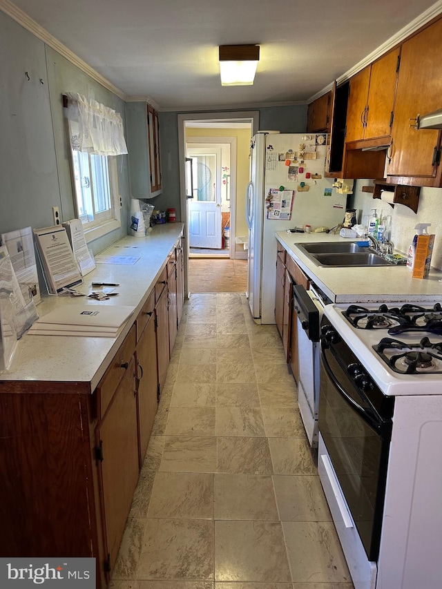 kitchen featuring crown molding, light countertops, brown cabinetry, stone finish flooring, and white appliances