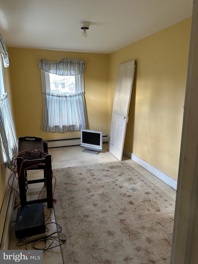 living area with a baseboard radiator and light colored carpet