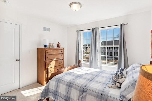 bedroom featuring light carpet and multiple windows