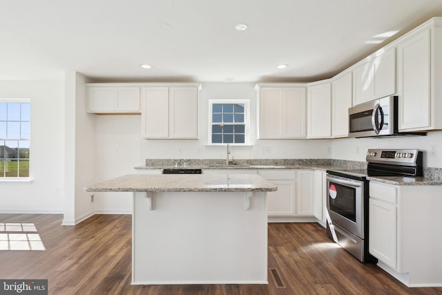 kitchen featuring a kitchen island, dark wood-type flooring, and stainless steel appliances