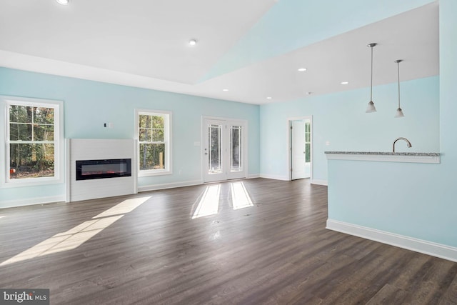 unfurnished living room with dark wood-type flooring and vaulted ceiling