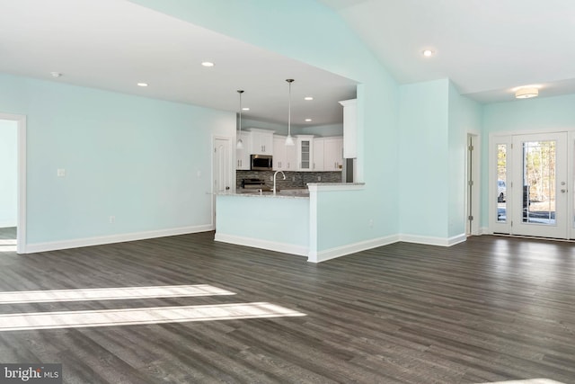 unfurnished living room with dark hardwood / wood-style floors and vaulted ceiling