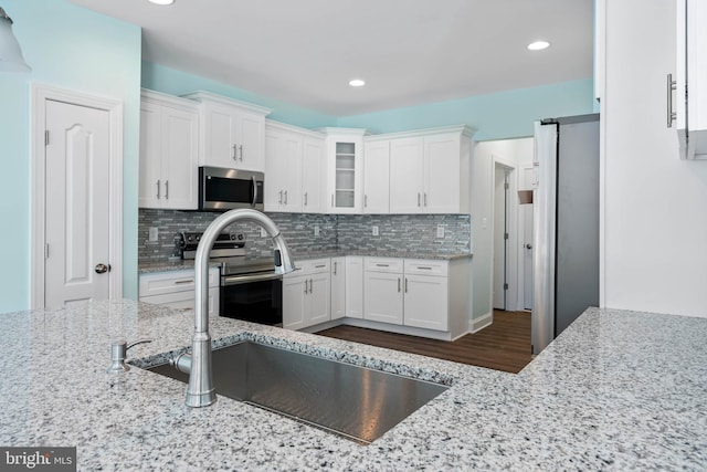 kitchen featuring backsplash, sink, white cabinetry, and stainless steel appliances