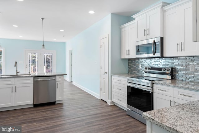 kitchen featuring white cabinets, hanging light fixtures, sink, and appliances with stainless steel finishes