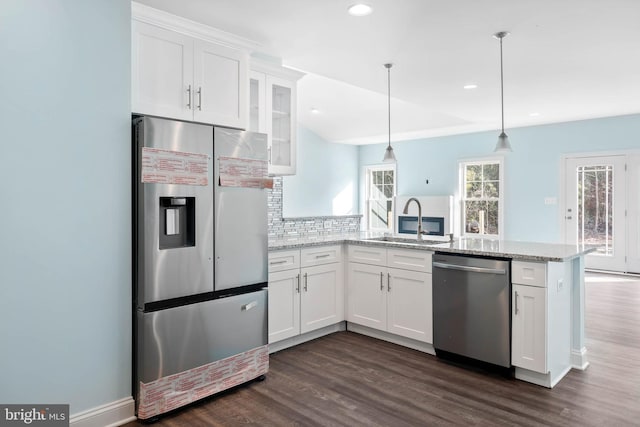 kitchen featuring white cabinets, decorative light fixtures, sink, and appliances with stainless steel finishes