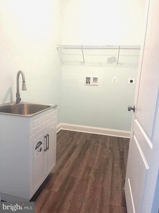 clothes washing area featuring electric dryer hookup, cabinets, sink, washer hookup, and dark hardwood / wood-style floors