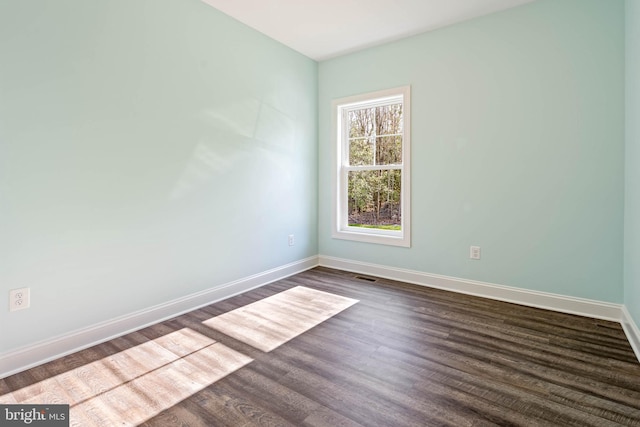 empty room with dark hardwood / wood-style flooring