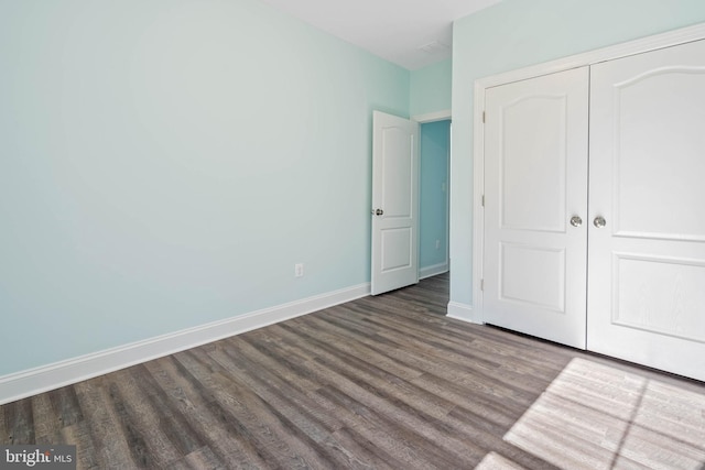 unfurnished bedroom featuring hardwood / wood-style floors and a closet