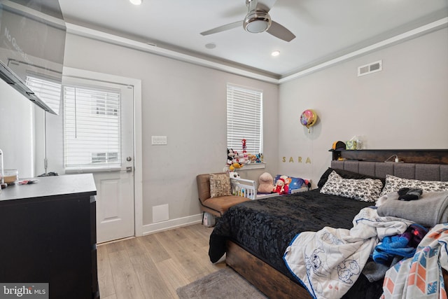 bedroom featuring multiple windows, ceiling fan, and light wood-type flooring