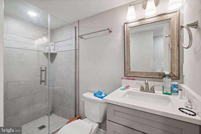 bathroom featuring toilet, a shower with shower door, and large vanity