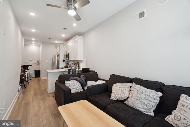 living room featuring ceiling fan and light wood-type flooring