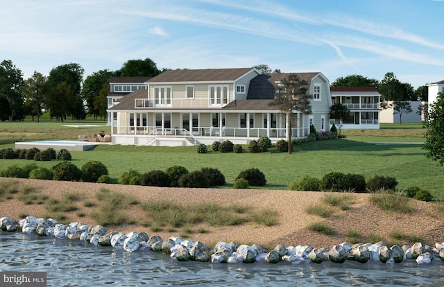 rear view of property featuring a lawn and a water view