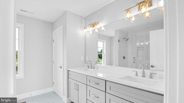 bathroom featuring a shower with door and vanity