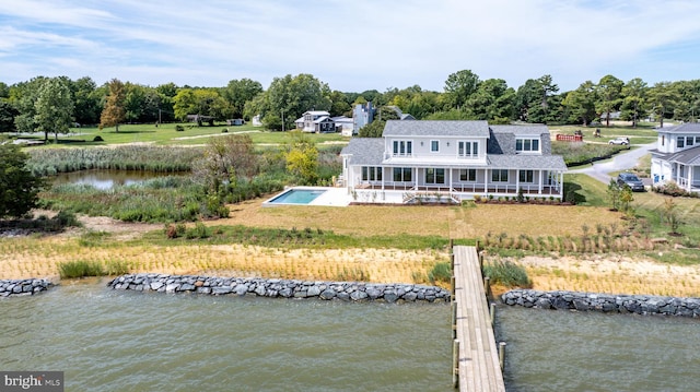 back of property featuring a water view and a yard