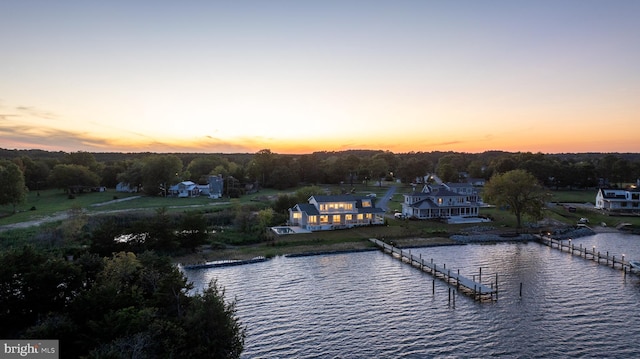 aerial view at dusk featuring a water view