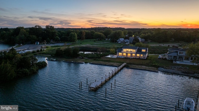 aerial view at dusk featuring a water view