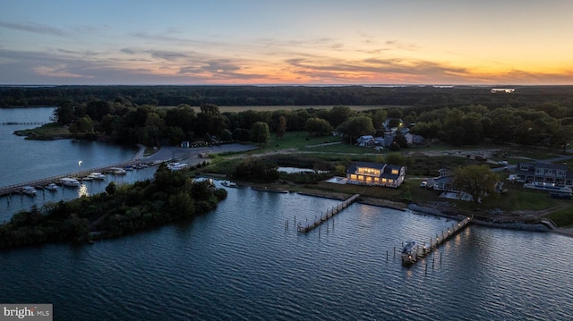 aerial view at dusk featuring a water view