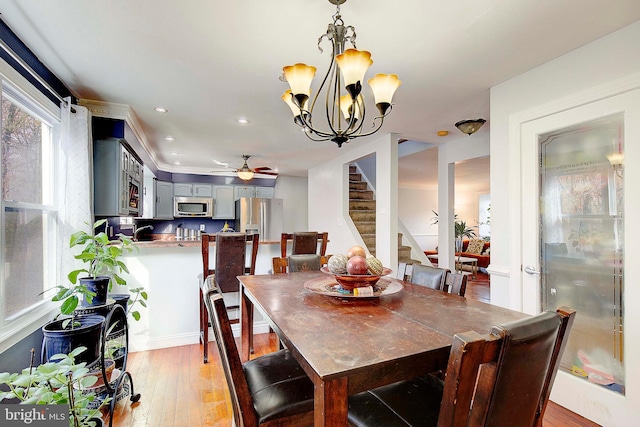 dining room featuring hardwood / wood-style floors and ceiling fan with notable chandelier