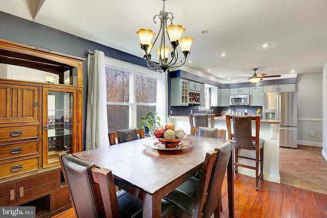 dining room with dark hardwood / wood-style floors and ceiling fan with notable chandelier