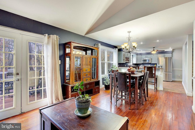 tiled dining room featuring lofted ceiling, ceiling fan with notable chandelier, and a wealth of natural light