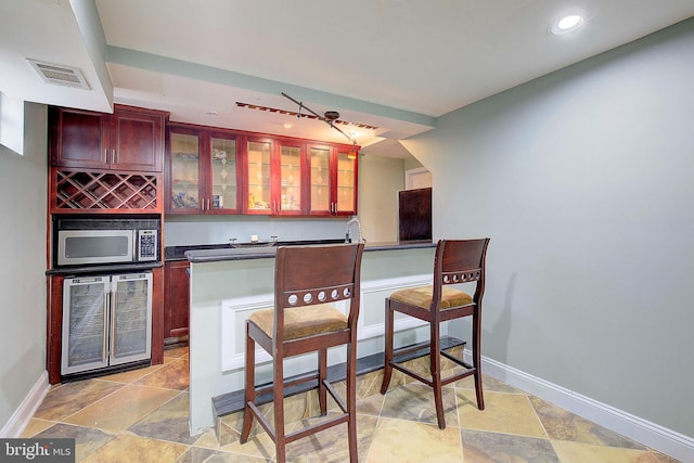 kitchen featuring beverage cooler and light tile floors