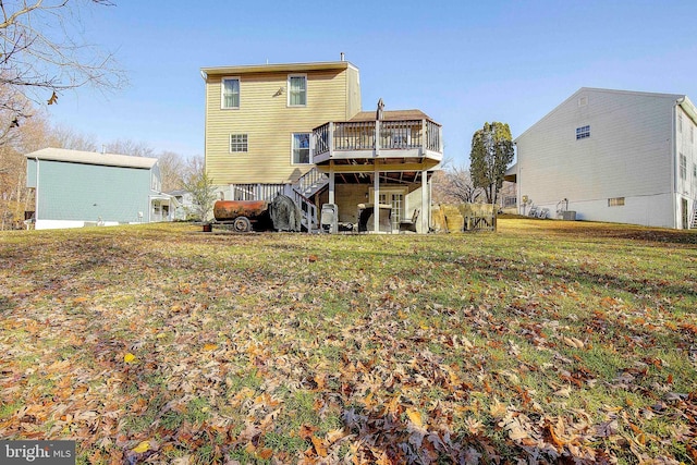 rear view of property featuring a deck and a lawn