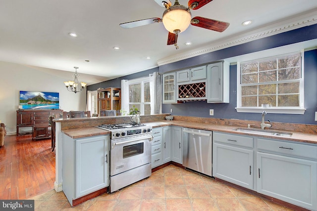 kitchen featuring ceiling fan with notable chandelier, high end white range oven, sink, light tile floors, and stainless steel dishwasher