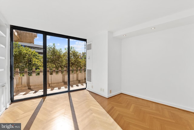 unfurnished room featuring light parquet floors and floor to ceiling windows