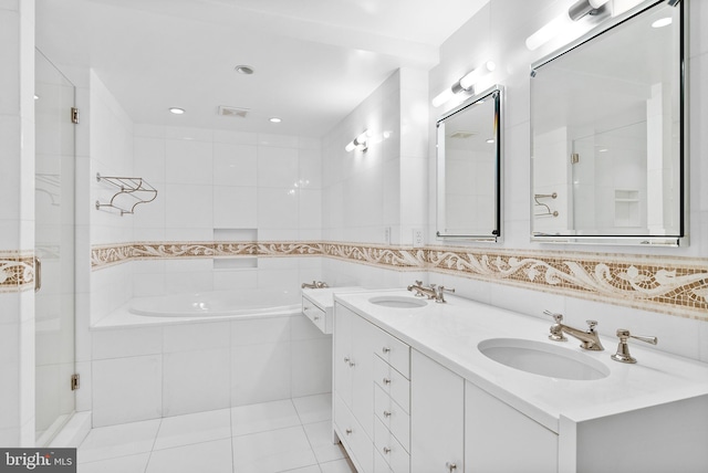 bathroom with oversized vanity, double sink, shower with separate bathtub, tile walls, and tile floors