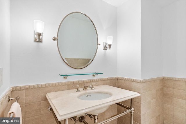 bathroom featuring tile walls and sink